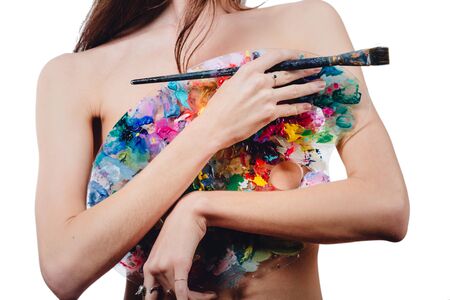 Nude attractive young female artist is holding a color palette and brush, looking at camera. studio white background.の写真素材