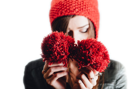 Pretty young woman wearing a hand knitted red hat on white background. Isolated. Beautiful girl in...