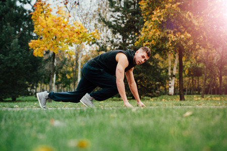 Fitness man training and jogging in fall park. Ready to start. Healthy lifestyleの写真素材