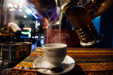 Pour tea into a cup at an Street cafe. Jets of steam. Arabic flavorの写真素材