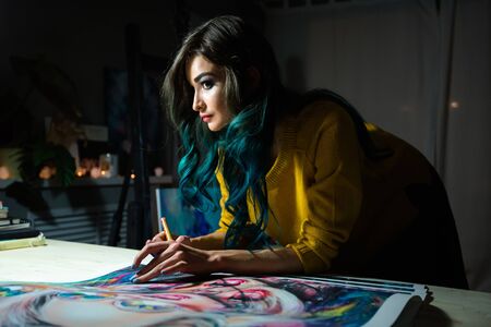 Girl artist signs some of his works. Painted sign of a master. Canvas on a stretcher signature black marker.の写真素材