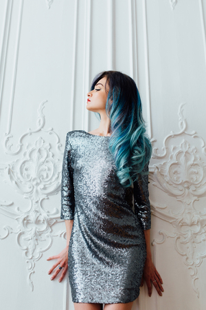 Fashion portrait of gorgeous girl with blue dyed hair long. The beautiful evening cocktail dress.の写真素材