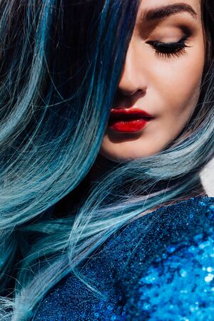 Fashion portrait of gorgeous girl with blue dyed hair long. The beautiful evening cocktail dress.の写真素材