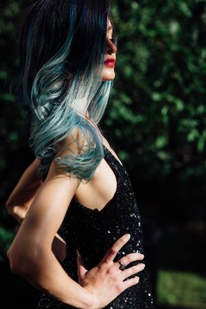 Fashion portrait of gorgeous girl with blue dyed hair long. The beautiful evening cocktail dress.の写真素材