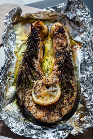 fish steak baked with lemon and herbs in foil.の写真素材