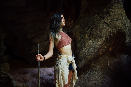 Young girl on the background of an old cave. The concept of harmony with nature .の写真素材