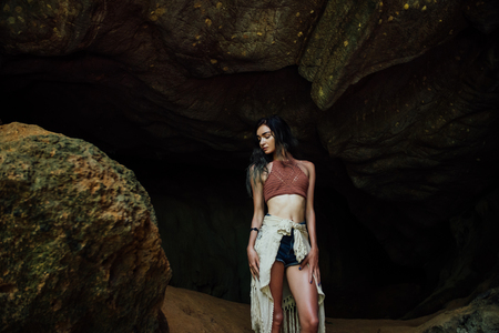 Young girl on the background of an old cave. The concept of harmony with nature .の写真素材