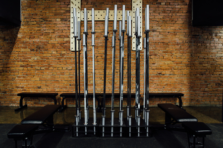 rack of chromed vertical dumbbells on the PEGBOARD wall background and Benches around.の写真素材