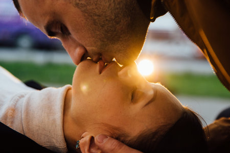 young couple kiss in sun beams