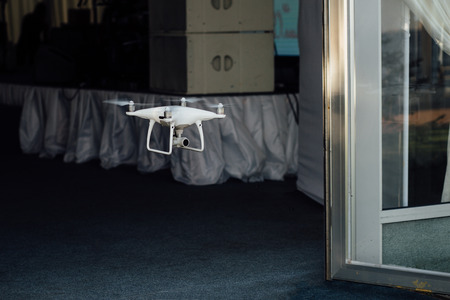 Drone quad copter spy flies through the door of the banquet hall of the cafe.の写真素材