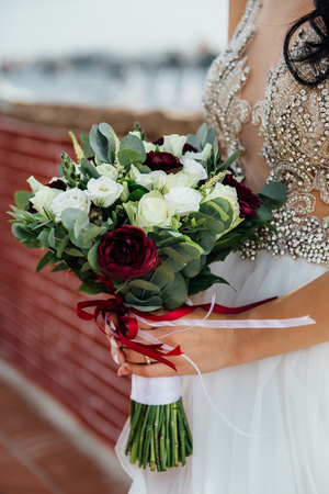 Wedding bouquet in bride hands, outdoor.の写真素材