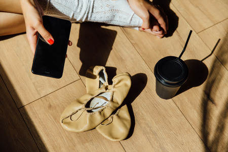 Portrait of Beautiful modern ballet dancer with perfect body sits on the floor in studio.の写真素材