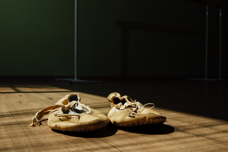 pair of old pointe ballet shoes on the floor. Dark background, copy sace.の写真素材