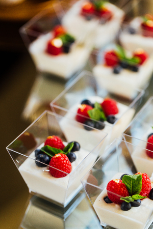 Snack at the wedding banquet in small shots of yogurt and berries.の写真素材