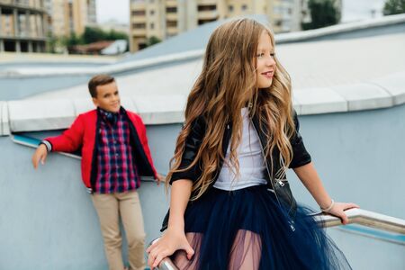 Two kids: Beautiful Children play on the railing in the street on the stairs.の写真素材