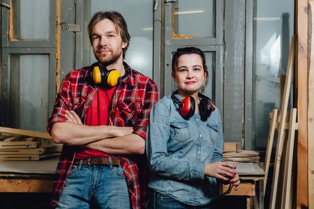 Portrait of carpenters in the workshop. A man and a girl, leaned back and posed.の写真素材