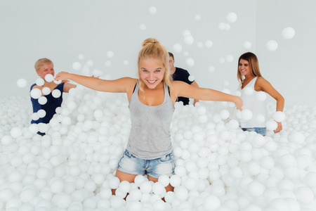 Happy Friendly family surrounded by white plastic balls in the dry pool.の写真素材