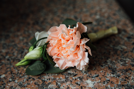 boutonniere, button hole flower, a cream peonies on granite table.の写真素材