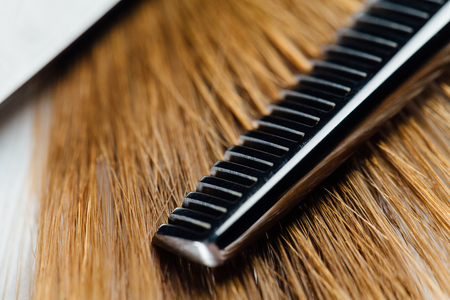 Professional scissors stylist hairdresser on the background of healthy beautiful hair. An example of a tester.の写真素材