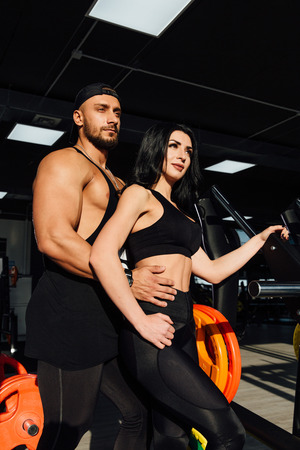 beautiful young sporty sexy couple man and girll pose standing in gym.の写真素材
