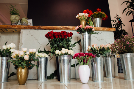 counter of the flower shop is filled with zinc vases with bouquets of various colors.の写真素材
