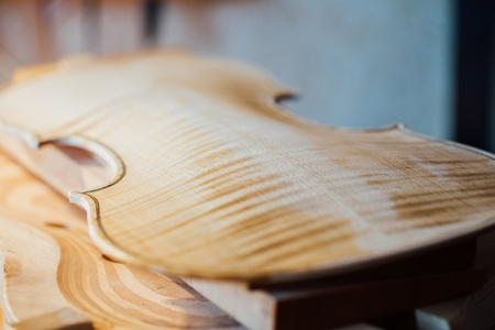 violin maker varnishing a violin body close up.の写真素材