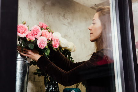 Florist woman on the work on flowers background.の写真素材