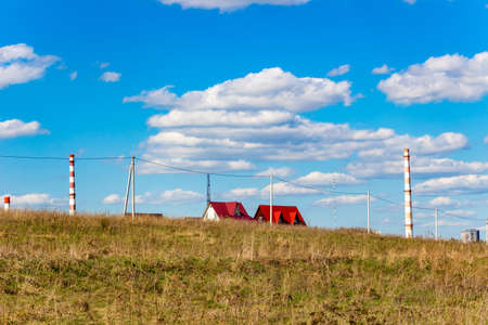 Roofs and chimneys tower over a landscape with a fieldの写真素材
