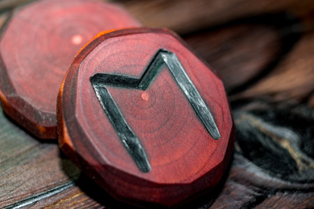 Rune Ehwaz red color carved from wood on a wooden background - Elder Futharkの写真素材