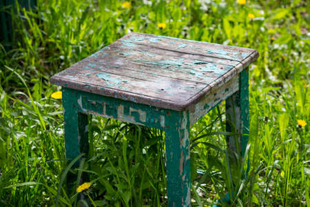 Old wooden stool in the grassの写真素材