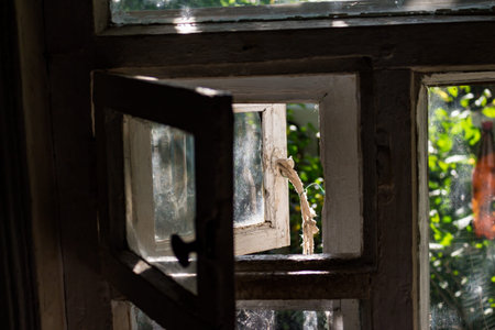 Small open window leaf in the window of a wooden house