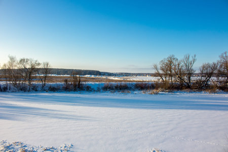 Panorama of a snow-covered river in a winter dayの写真素材
