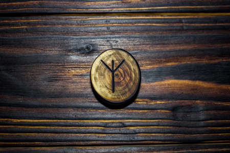 Rune Algiz (Elhaz) carved from wood on a wooden background - Elder Futharkの写真素材