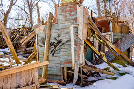 Demolished wooden structure in a forest area in winter. Former pioneer camp in Russia