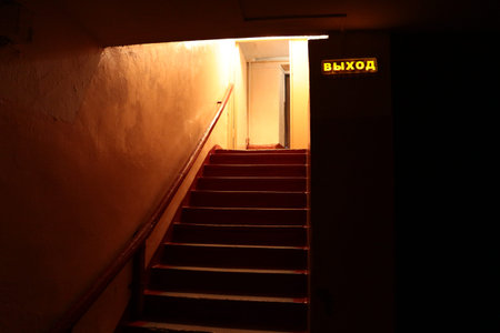 The inscription Exit in Russian. Leaving the basement of the Soviet bomb shelter under the school,...