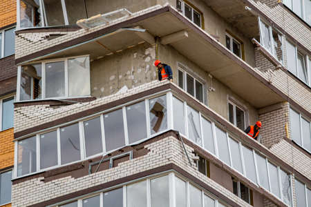 Obninsk, Russia - April 22, 2018: Damage to loggias on a 20-storey house as a result of a strong hurricane wind. Workers dismantle damaged structuresのeditorial素材