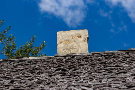 Roof and roofing of an old wooden village house with a chimneyの写真素材