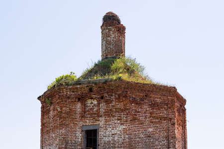 The tholobate of an old brick Orthodox church overgrown with grass. Village Fedorovskoe, Kaluzhskiy region, Russiaの写真素材
