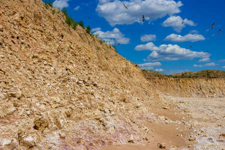 Colorful view of a limestone quarry, swallows flying against a blue skyの写真素材