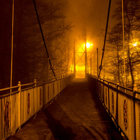 Pedestrian bridge in dense fog at night, foggy evening