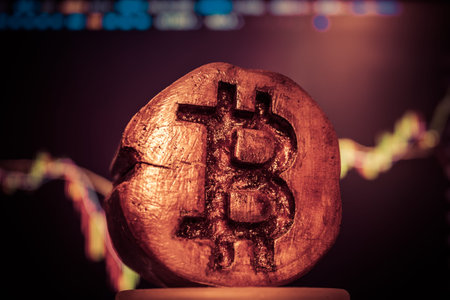 Wooden bitcoin on the background of the graph