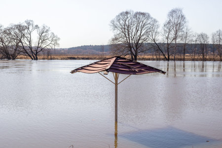 The flood of the river in spring in high water, beach umbrellas in the water