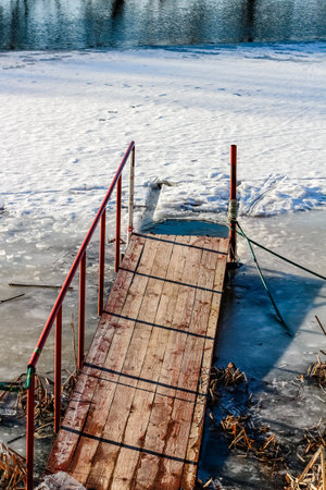 Pier for dipping in the ice on the river bankの写真素材