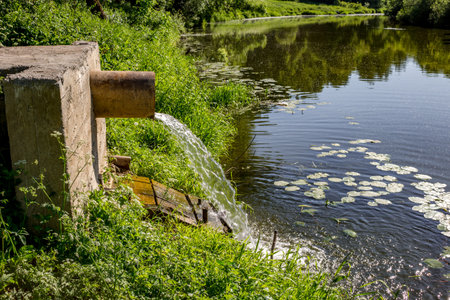 Drain water from the pipe into the riverの写真素材