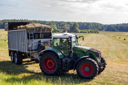 Kaluga region, Russia - June 2018: Harvesting of bales with agricultural equipmentのeditorial素材