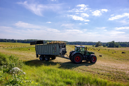 Kaluga region, Russia - June 2018: Harvesting of bales with agricultural equipmentのeditorial素材