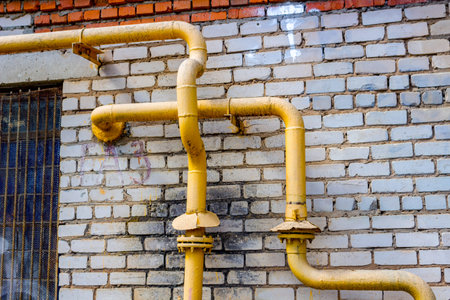 Yellow gas pipes on the wall facadeの写真素材