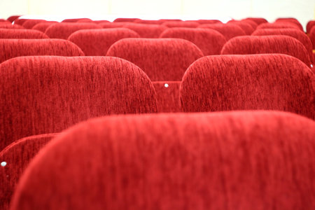 The backs of the red chairs in the auditorium, empty hallの写真素材