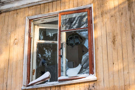 Broken window in an old abandoned house, view of the kitchen with a chandelierの写真素材