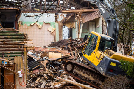 Demolition of an old wooden log house with a Volvo excavator: Kaluzhskiy region, Russia - April 2021のeditorial素材